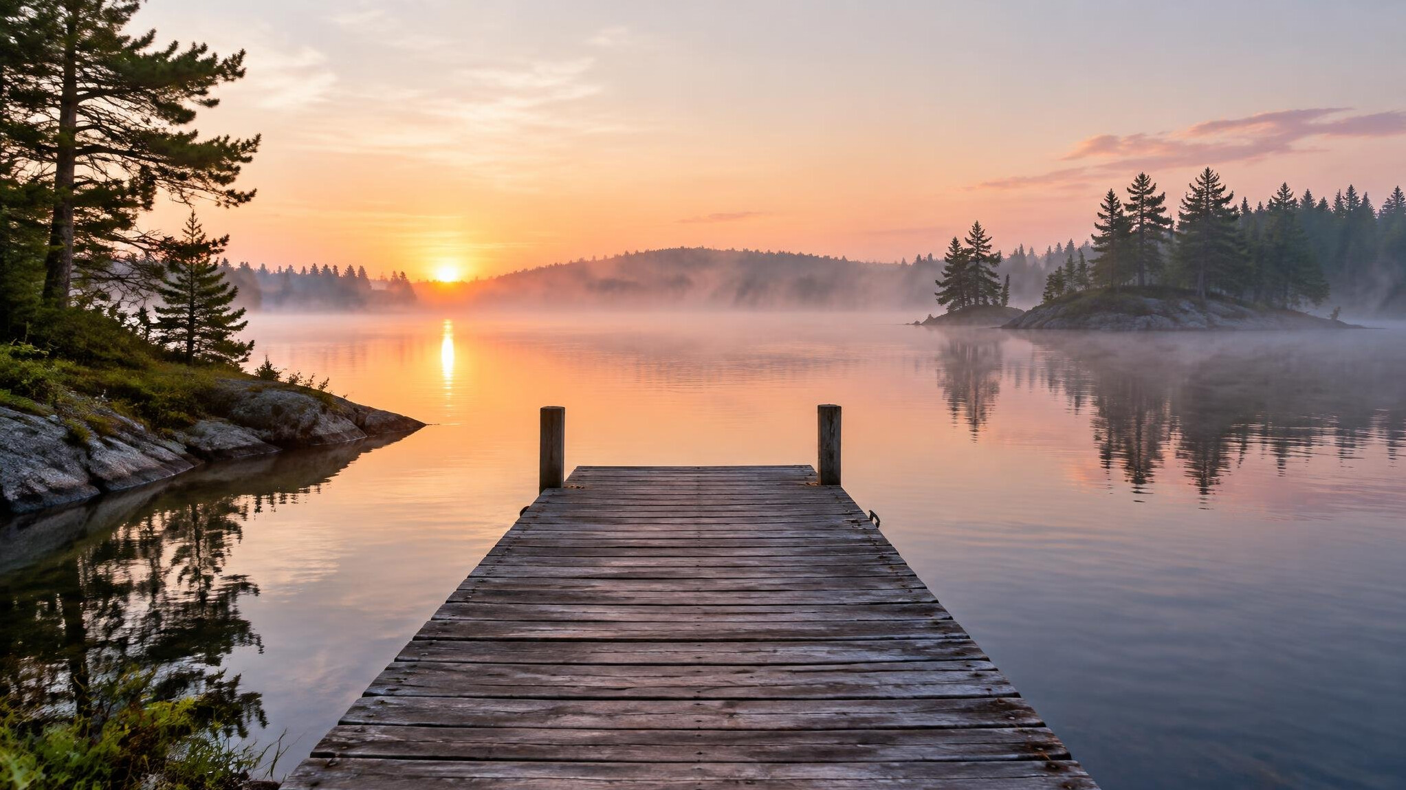Wooden dock on a calm Ontario lake at sunrise