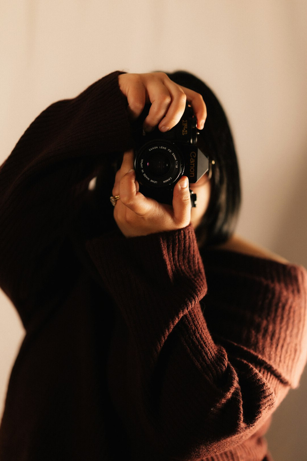 Studio portrait of a woman photographer holding a camera